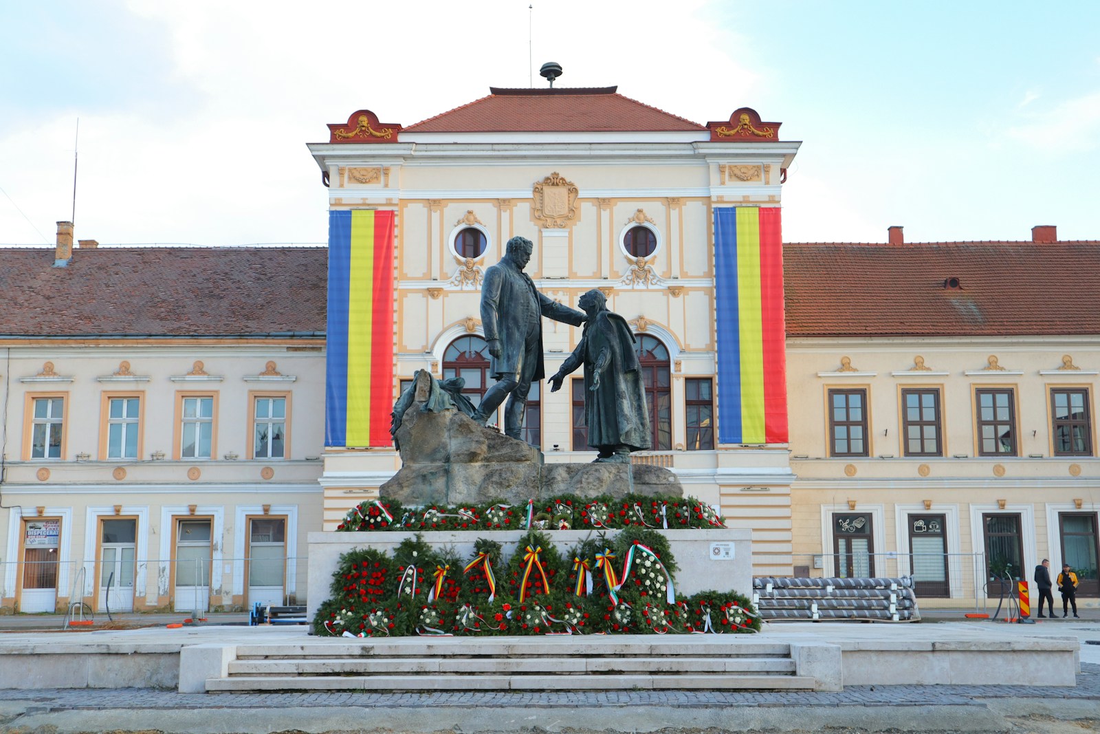 a statue of two men shaking hands in front of a building